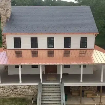 A recently renovated house with a standing seam copper porch roof